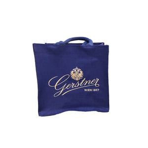 Eine Blaue Stofftasche mit dem Gerstnerlogo in Gold. 