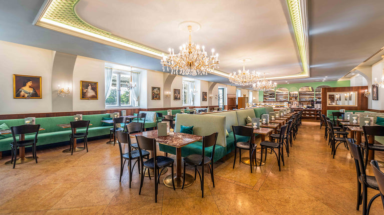 Das Café-Restaurant Gerstner K. u. K. Hofzuckerbäcker im Schloss Schönbrunn in Wien. Es befindet sich im Kavalierstrakt des Schlosses Schönbrunn. Das Interieur ist elegant gestaltet, mit Kronleuchtern und grünen Samtsitzbänken.