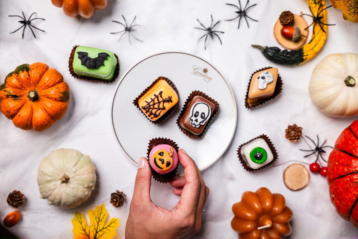 Verschiedene Sorten Petit Fours mit Halloween Dekor auf einem schönen Teller.