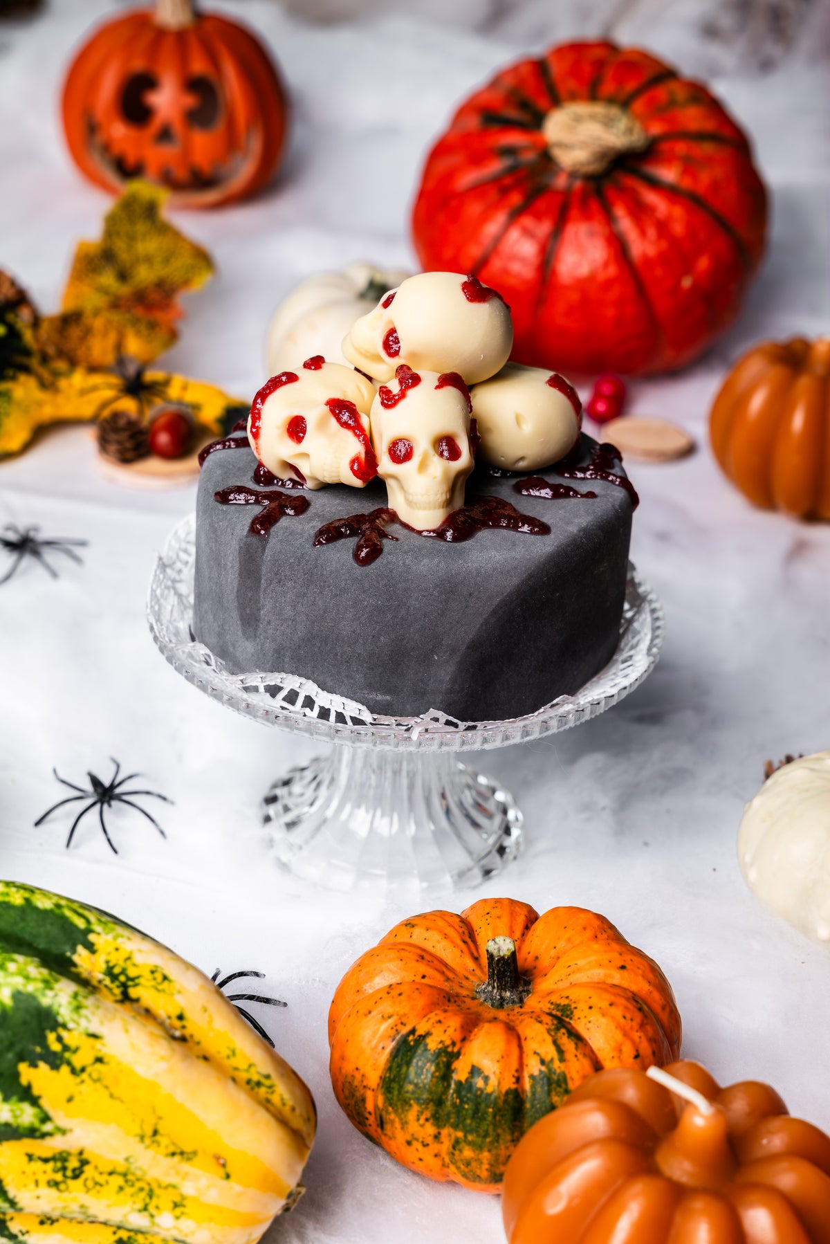 Halloween Sachertorte mit Totenköpfen als Dekor auf einem edlen Teller.