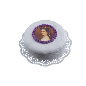 Sisi Torte für die Blechdose auf einer weißen Spitzentortenunterlage. 