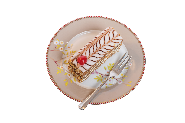 Ein Stück Esterházy Schnitte auf einem rosa Teller aus der Vogelperspektive