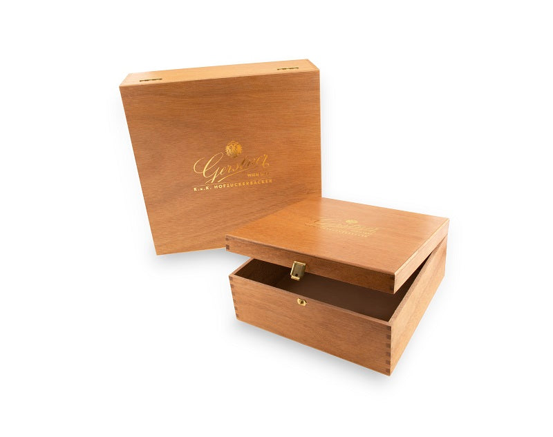 Eine geöffnete Holzbox mit einem goldenen Logo auf der Vorderseite, elegant und schlicht gestaltet.
