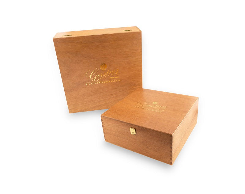 Eine Holzbox mit einem goldenen Logo auf der Vorderseite, elegant und schlicht gestaltet.