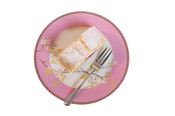 Ein Stück Kardinalschnitte auf einem rosa Teller aus der Vogelperspektive